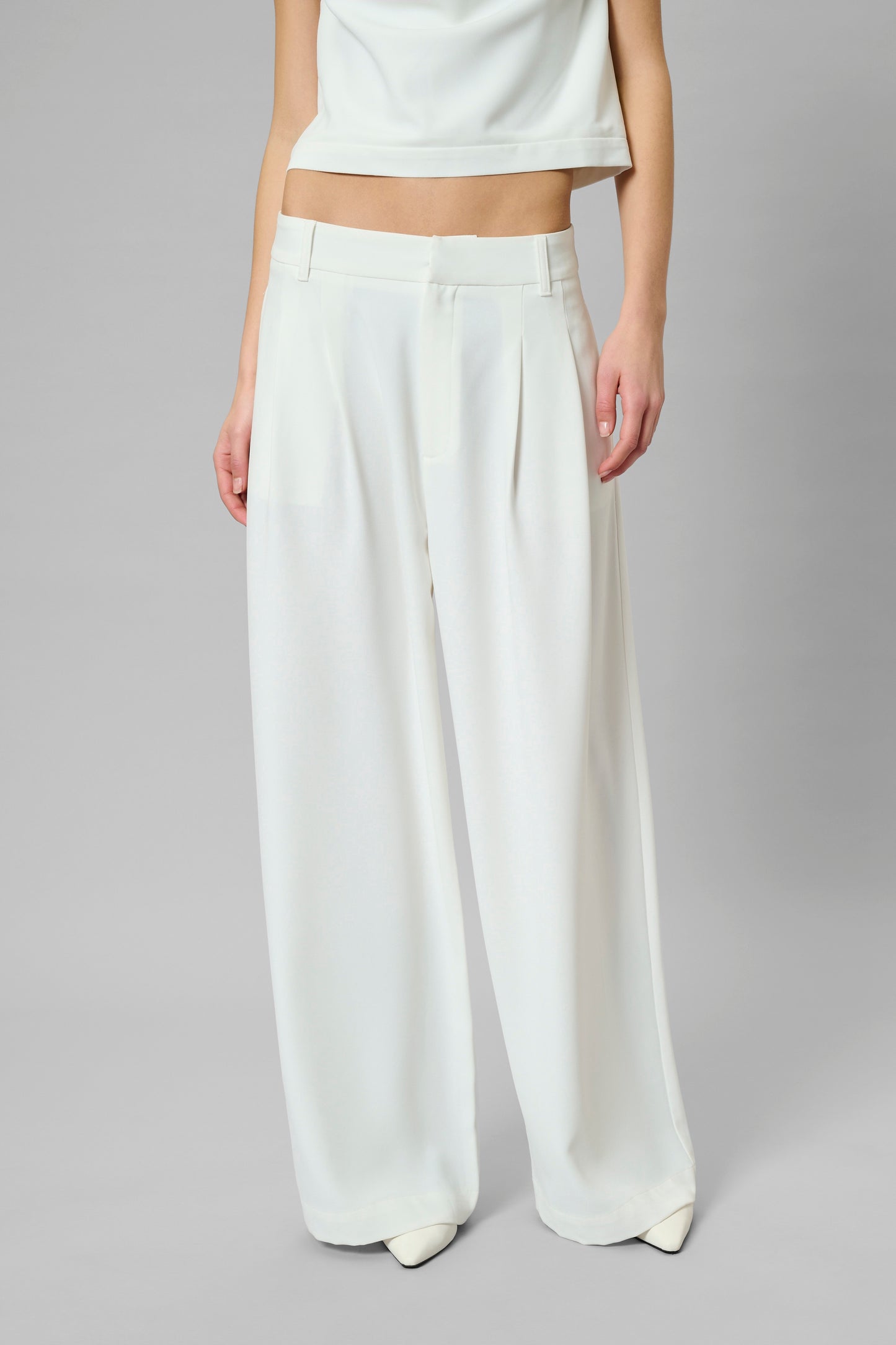 White wide-leg pants worn by a person on a gray background