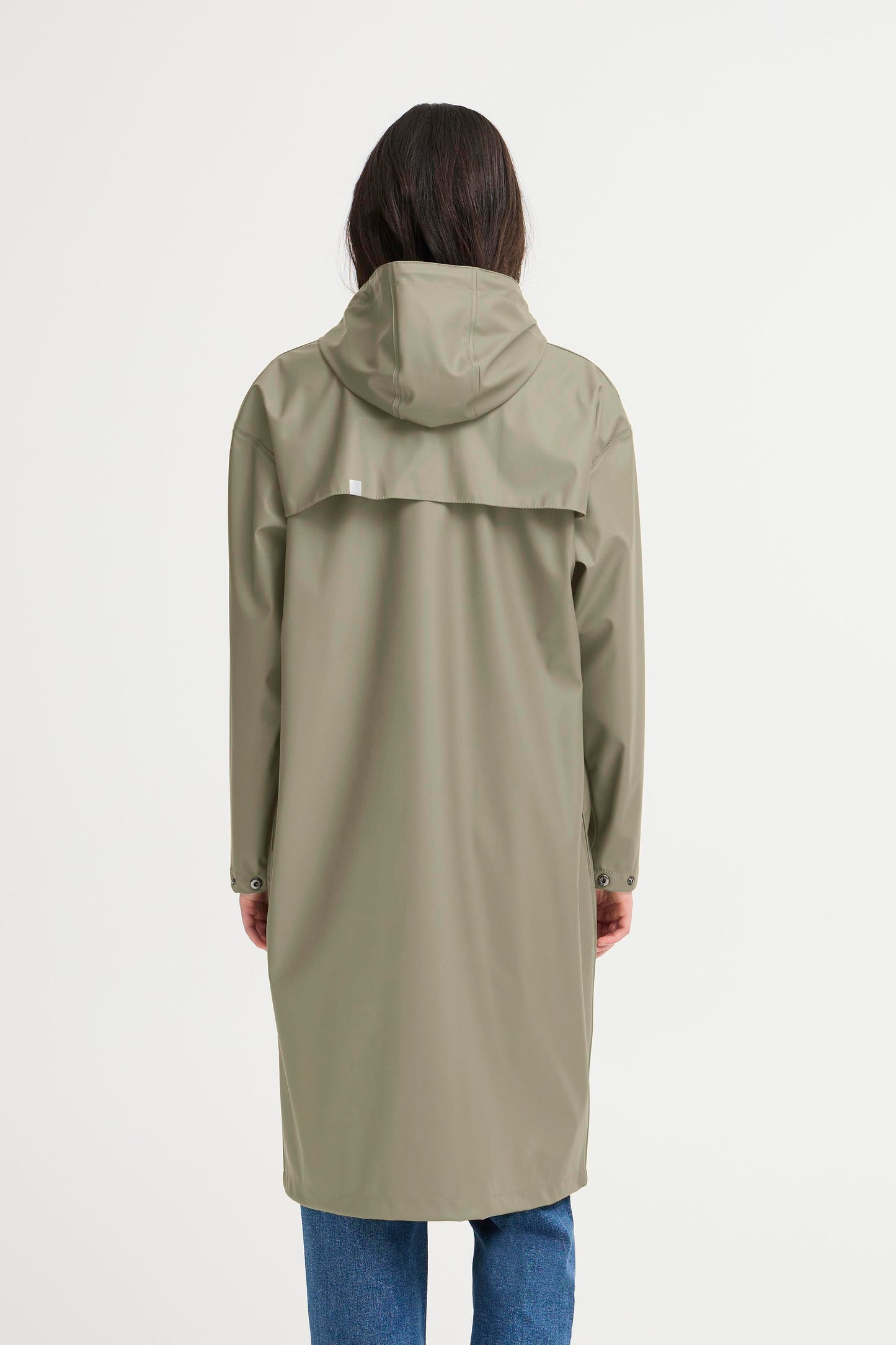 Person wearing a long green raincoat on a white background