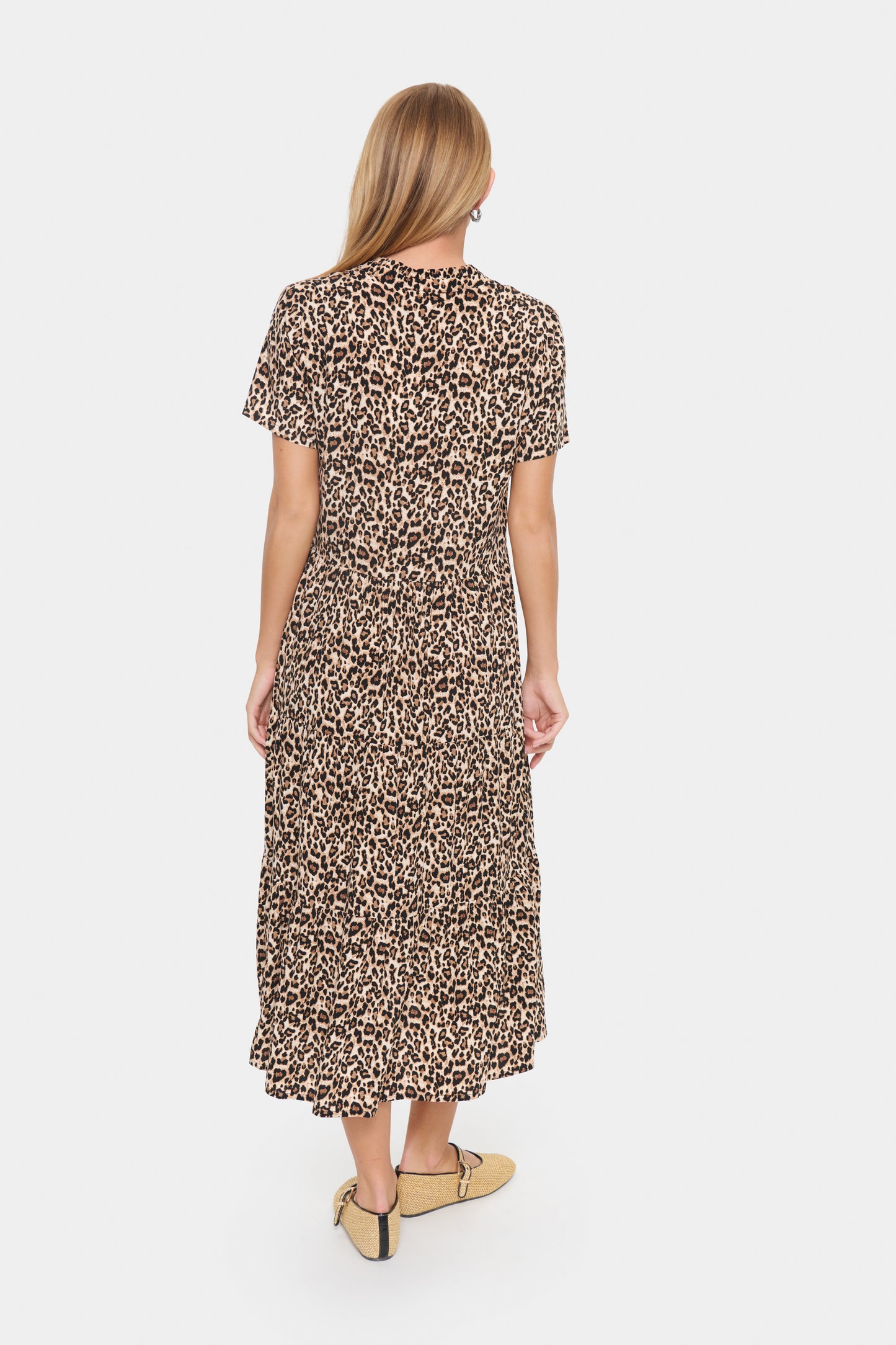 Woman wearing a leopard print dress on a white background