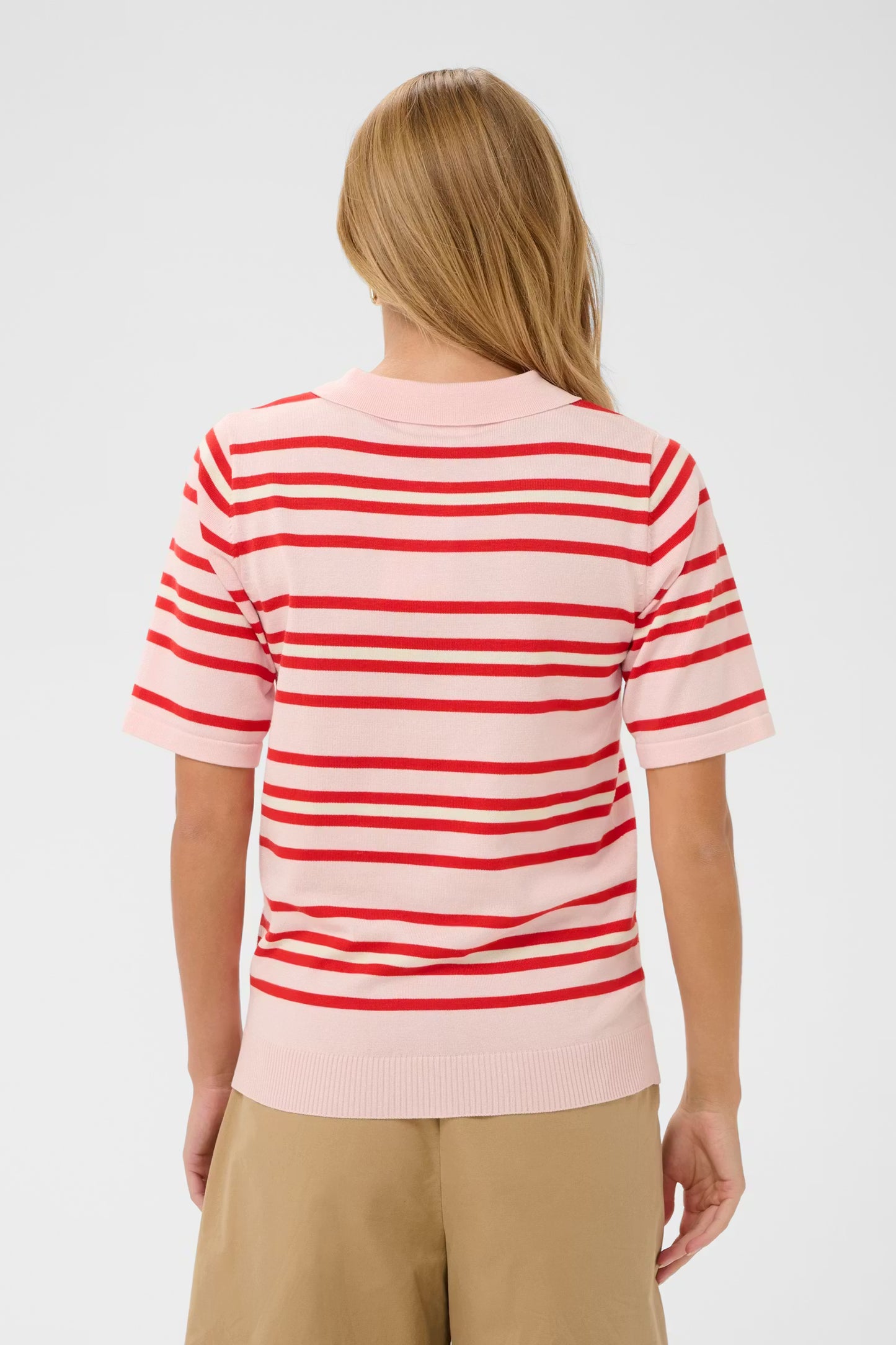 Person wearing a red and white striped shirt on a plain background