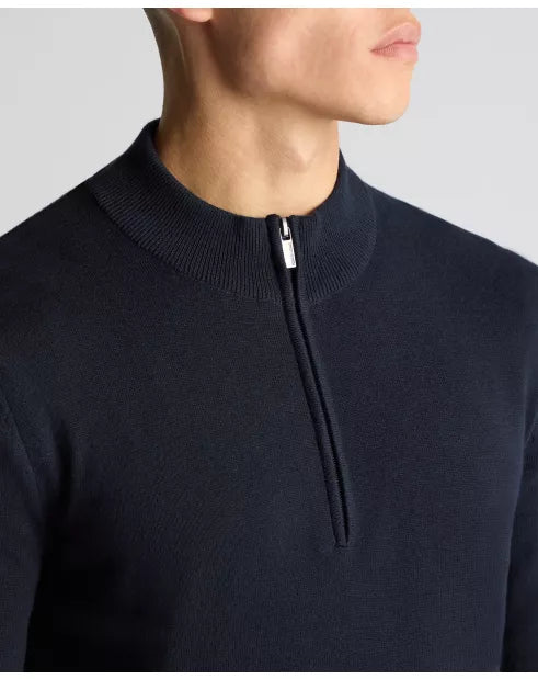 Navy blue sweater with a quarter zip on a neutral background