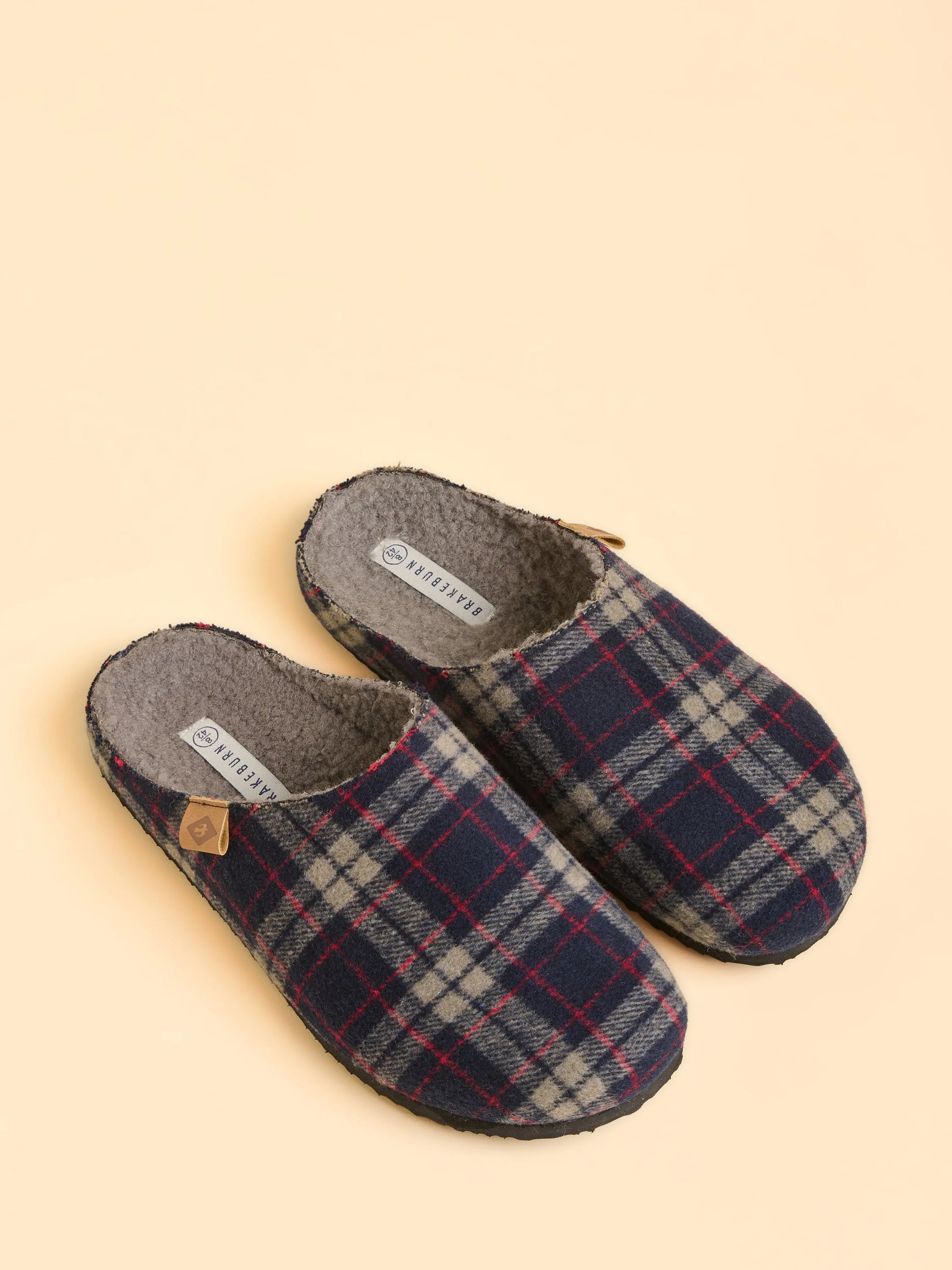 Plaid patterned slippers on a beige background