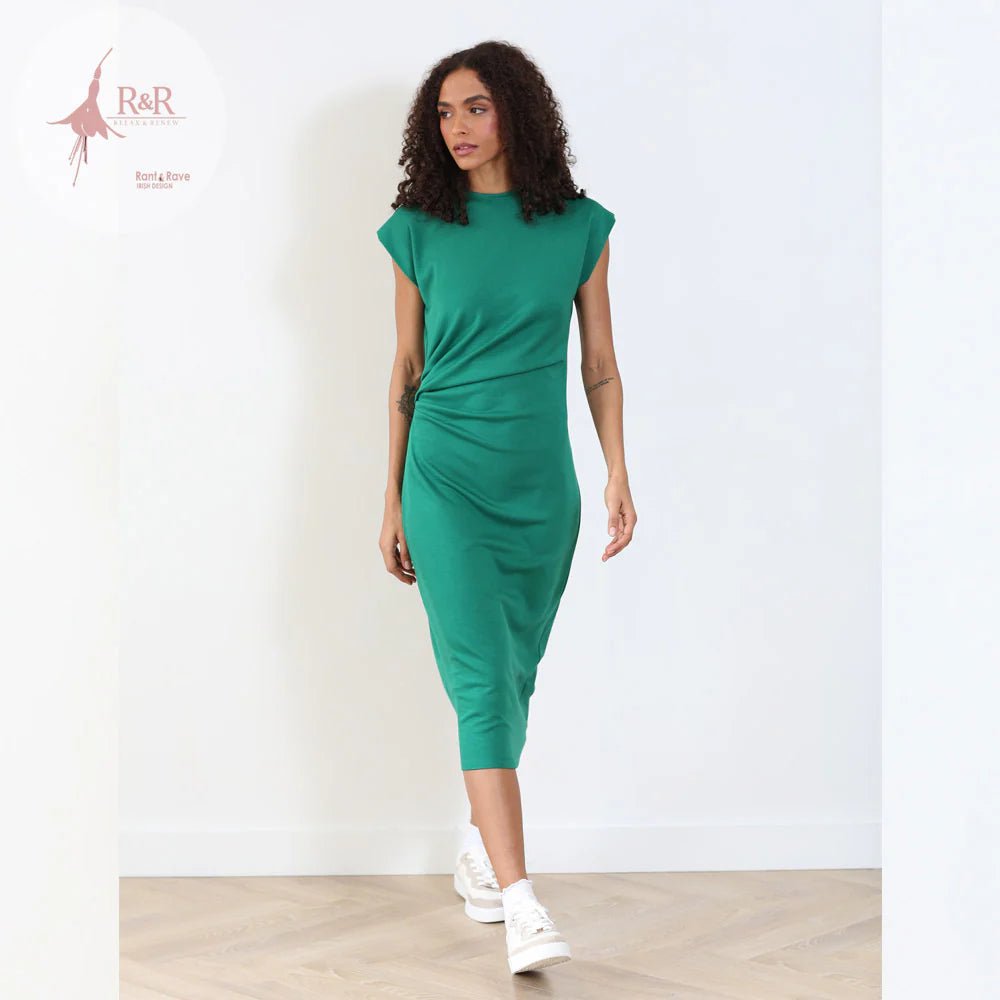 Woman wearing a green dress against a white background with 'R&R' branding.