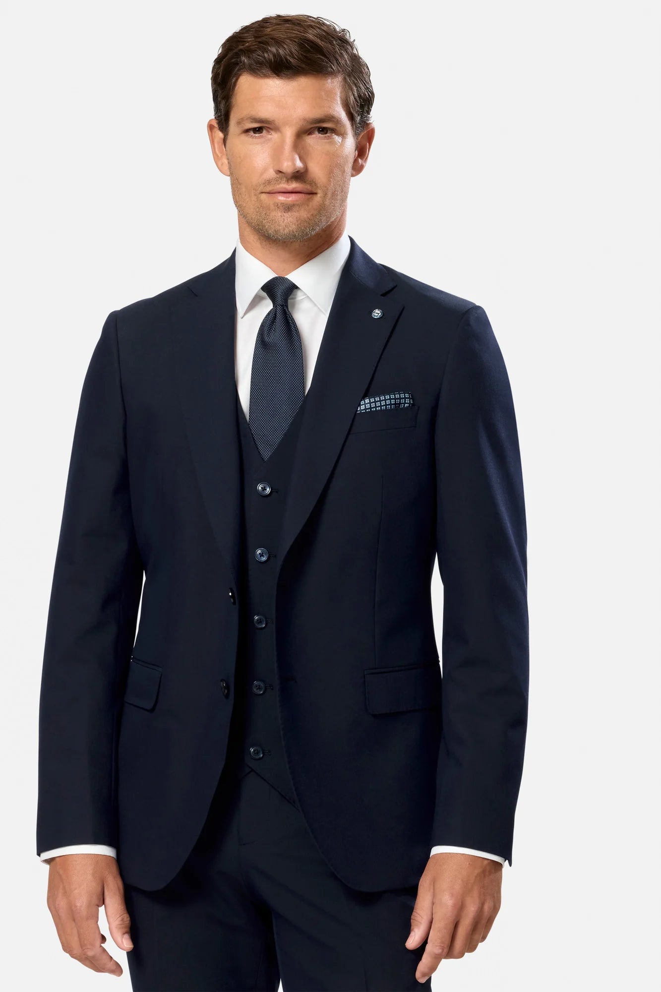 Man wearing a navy blue suit with a white shirt and tie on a white background