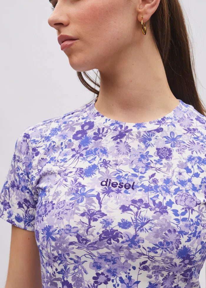 Woman wearing a floral-patterned t-shirt with 'Diesel' logo on a plain background