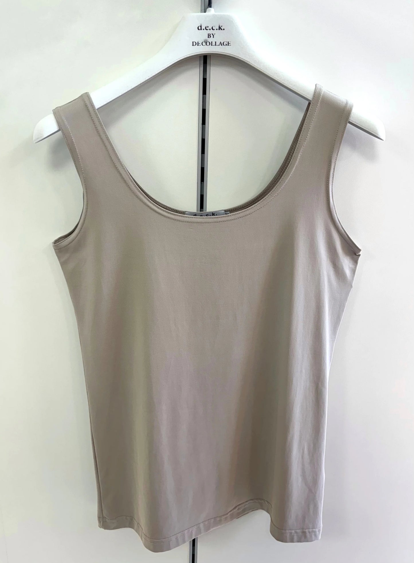 Beige tank top on a hanger against a white background