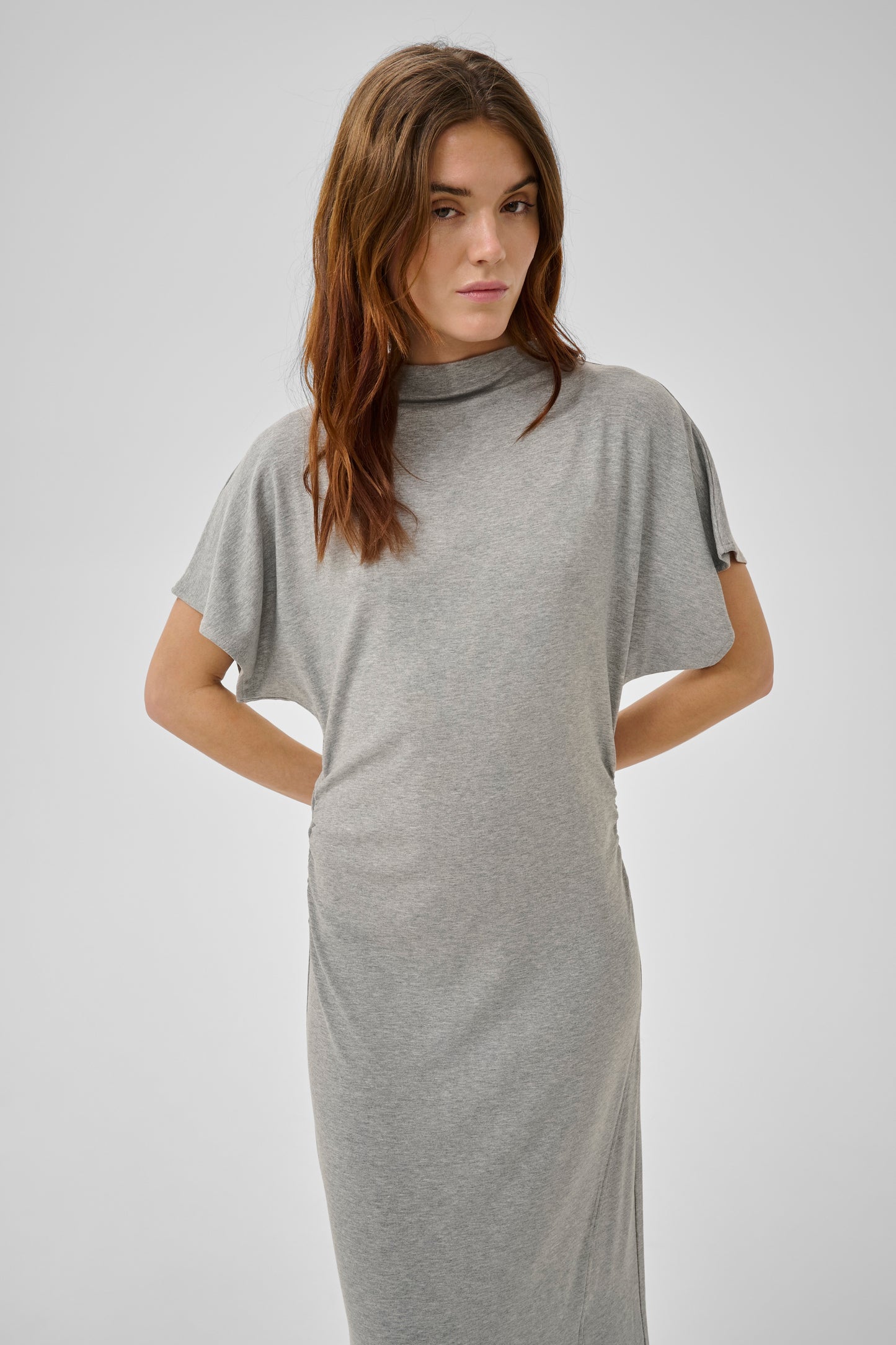 Woman wearing a gray dress against a plain background
