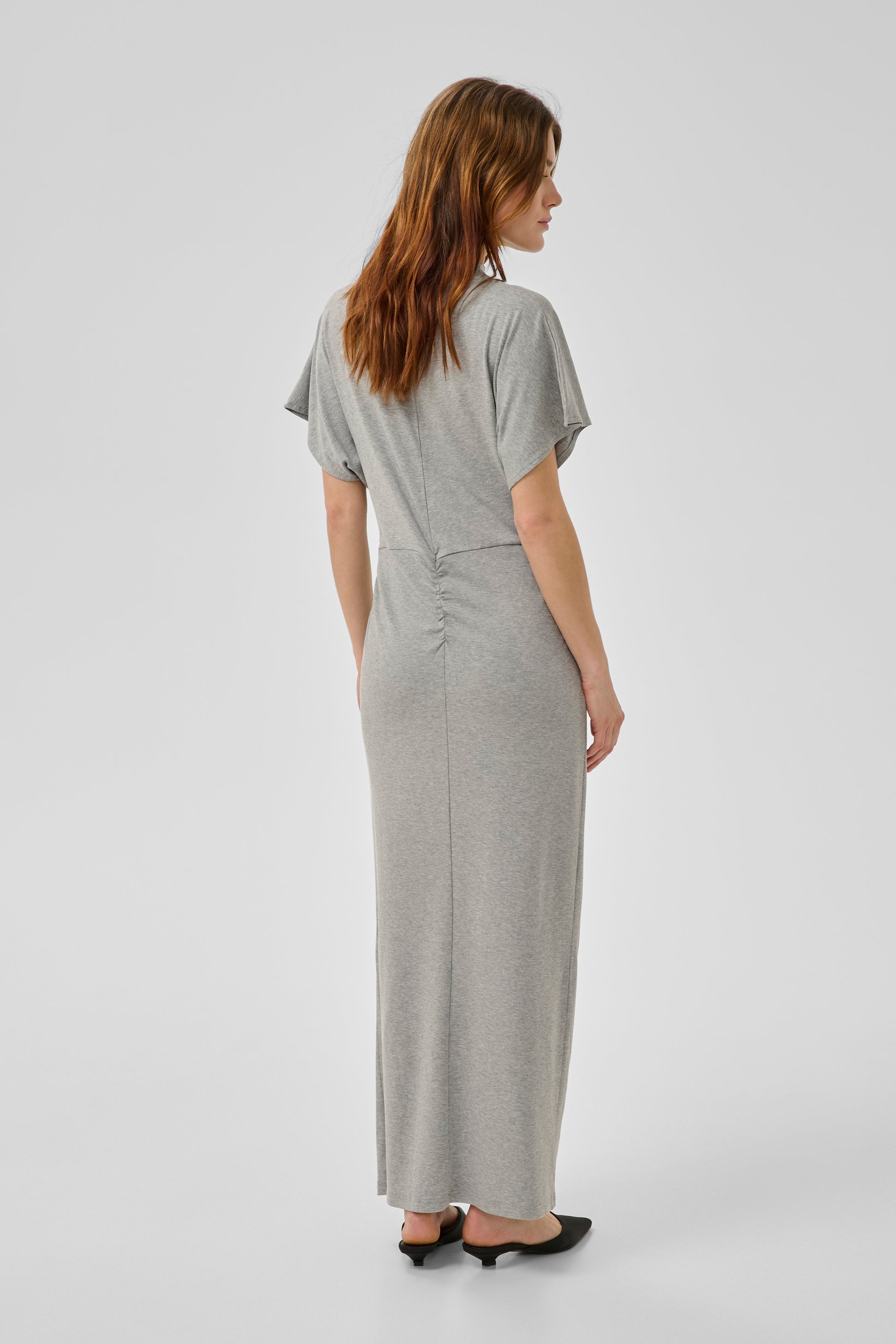 Woman wearing a gray dress on a white background