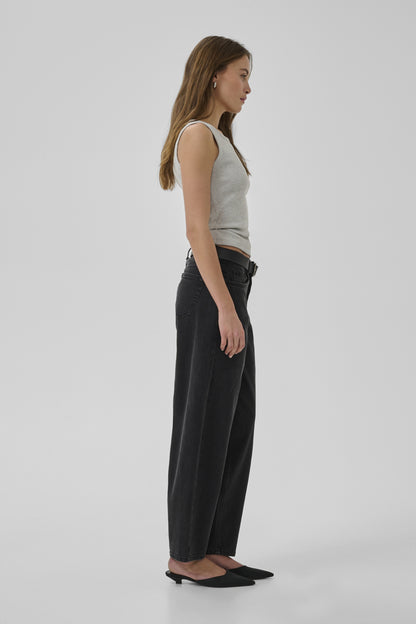 Woman wearing a gray tank top and black pants on a white background