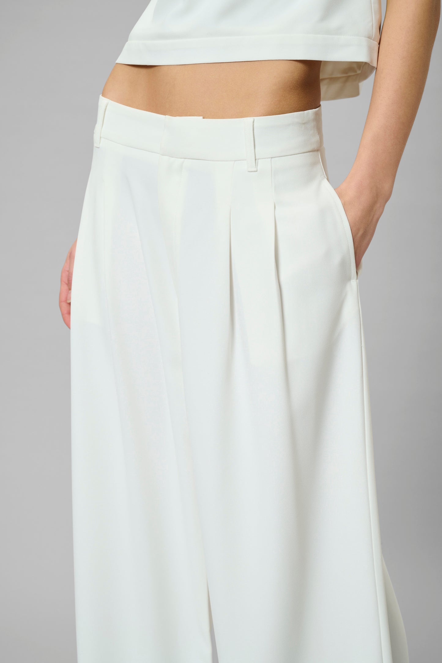 White wide-leg pants worn by a person on a gray background