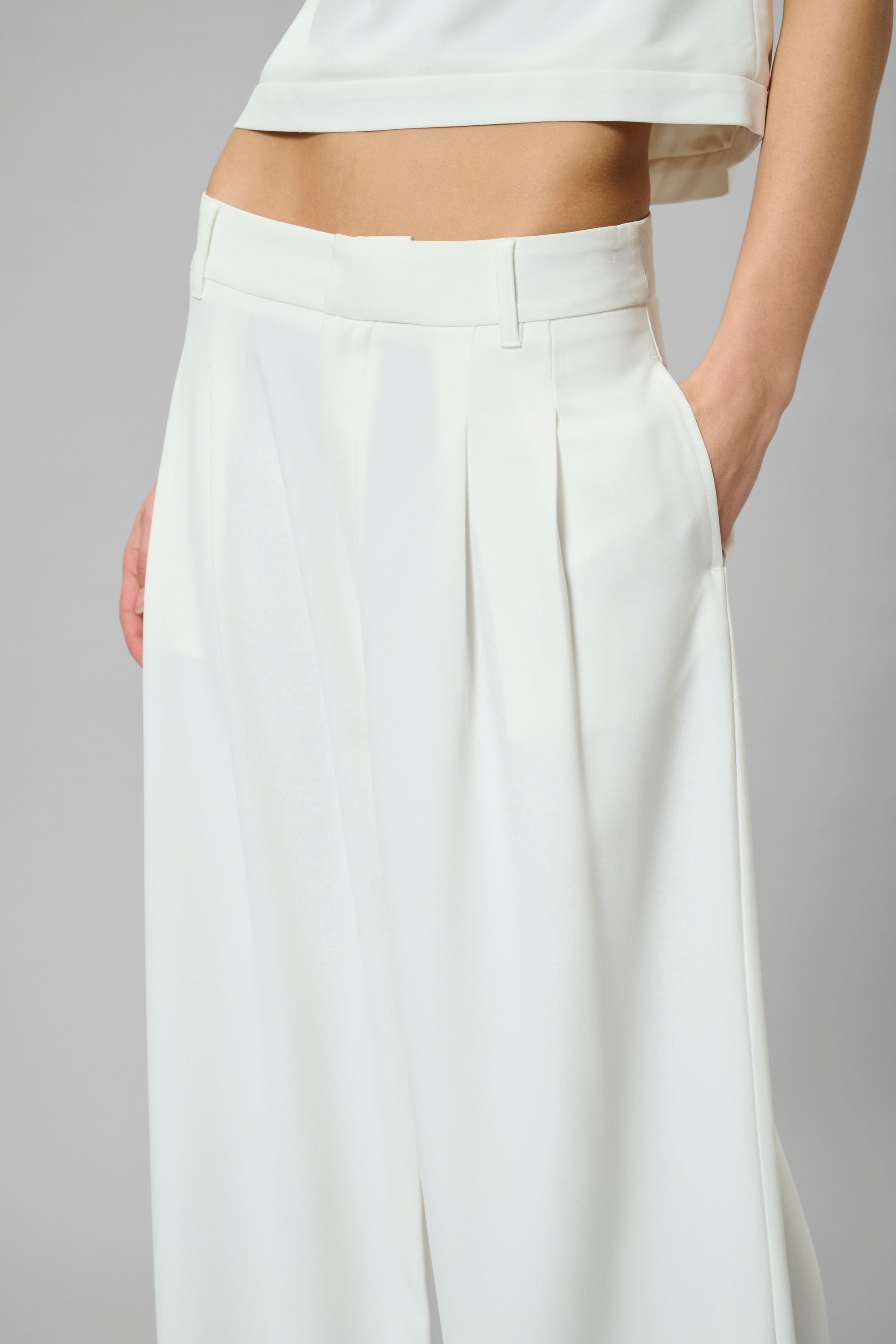 White wide-leg pants worn by a person on a gray background