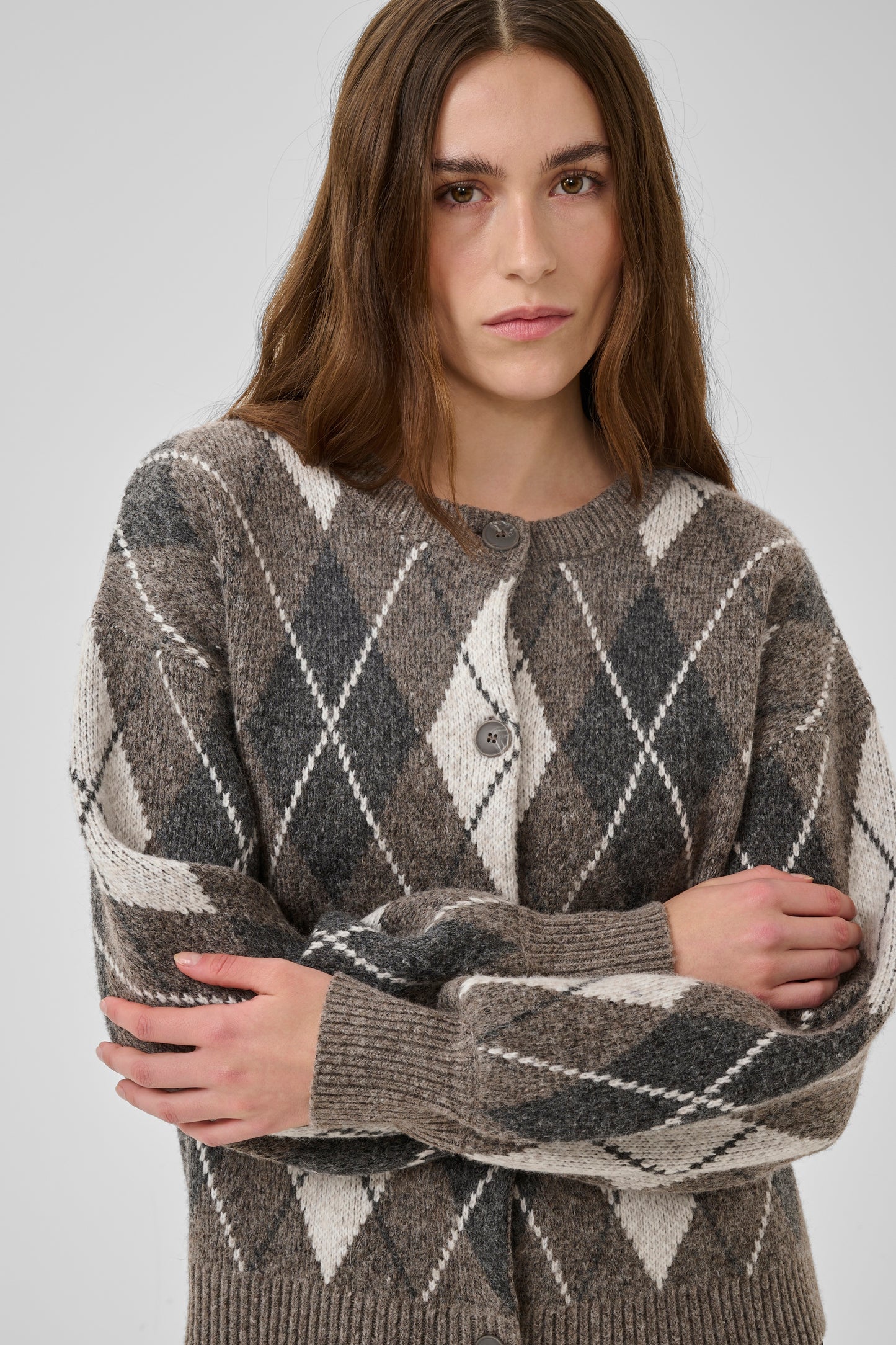 Woman wearing a patterned sweater against a plain background