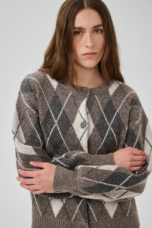 Woman wearing a patterned sweater against a plain background