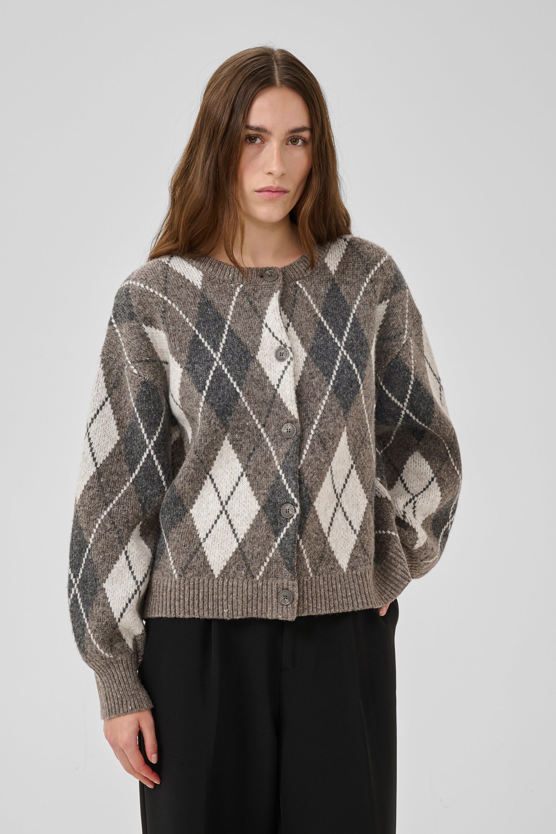 Woman wearing a patterned sweater against a plain background