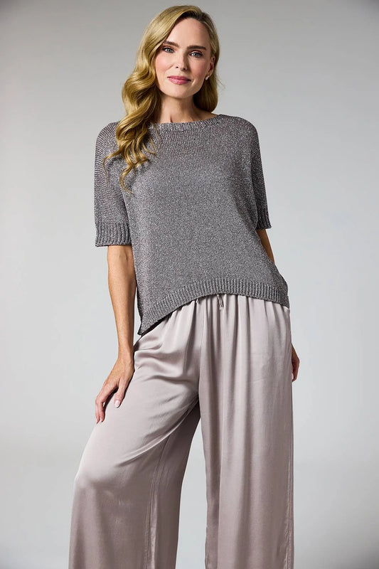A woman modeling a short-sleeve knit top in heather gray with matching gray trousers, photographed against a plain light gray studio background.