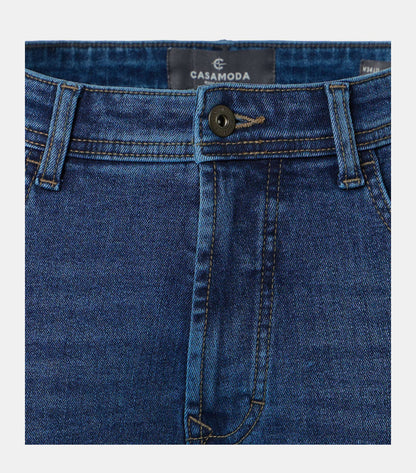 Close-up of blue denim jeans showing the waistband, belt loops, button closure, front fly, and pocket edges. The inner label reads CASAMODA.