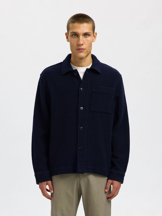 Man wearing a navy blue jacket on a white background