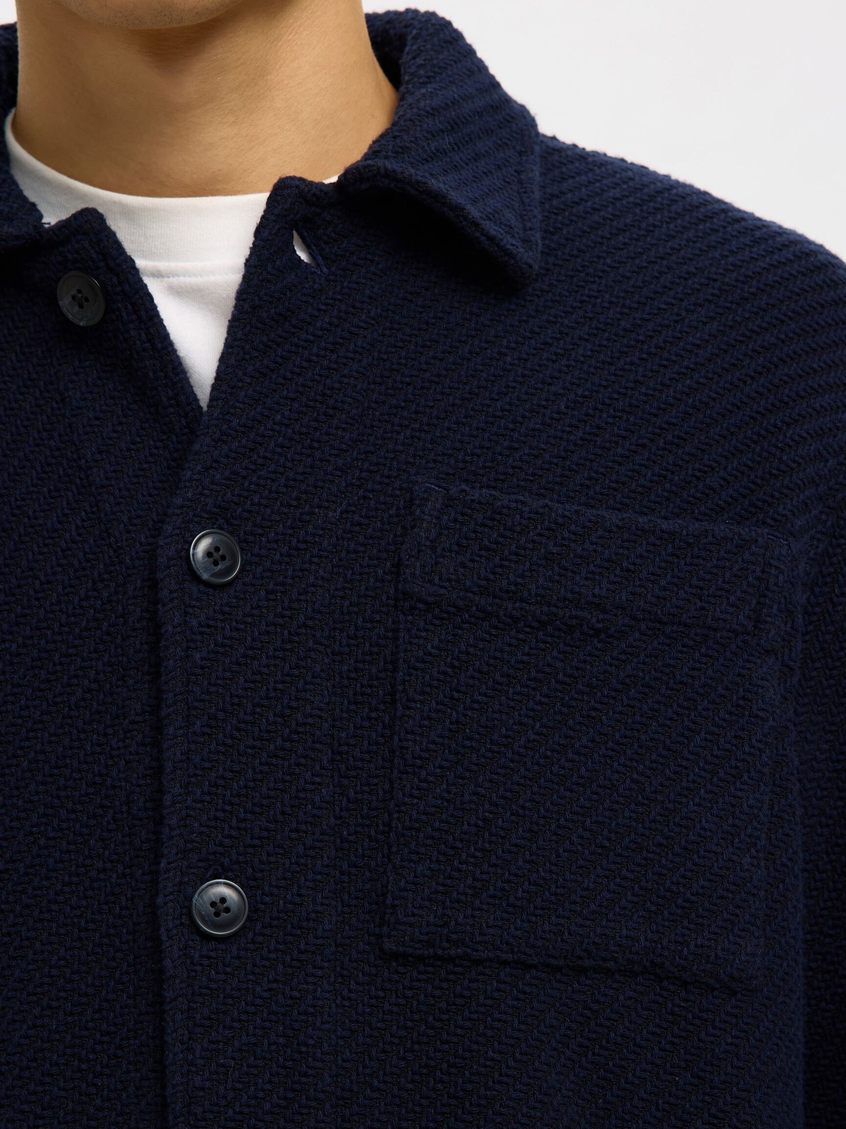 Navy blue textured jacket with buttons and a collar on a white background