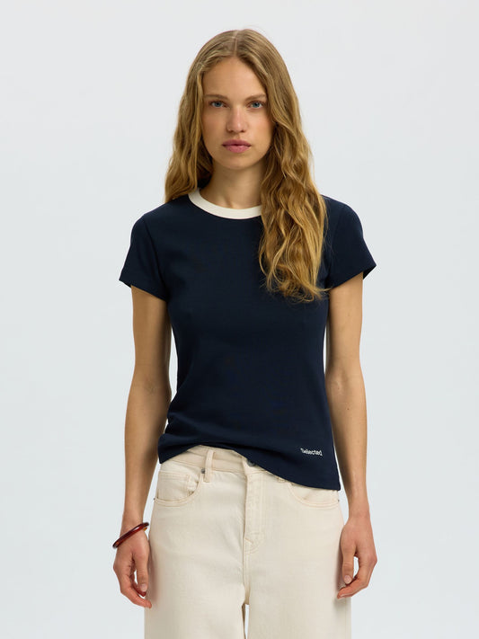 Woman wearing a navy blue t-shirt with a brand logo on a light gray background
