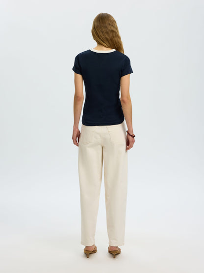 Woman wearing a black t-shirt and beige pants on a white background