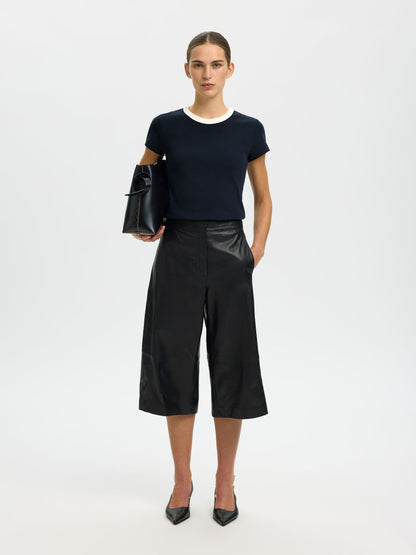 Person wearing a black outfit with a white background
