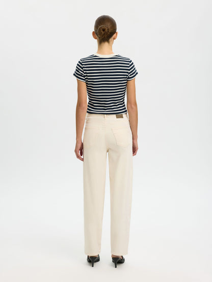 Person wearing a striped shirt and beige pants on a white background