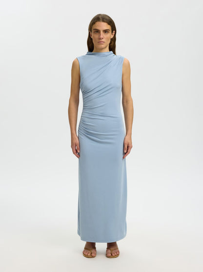 Woman wearing a light blue sleeveless dress on a white background