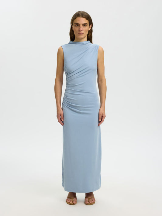 Woman wearing a light blue sleeveless dress on a white background