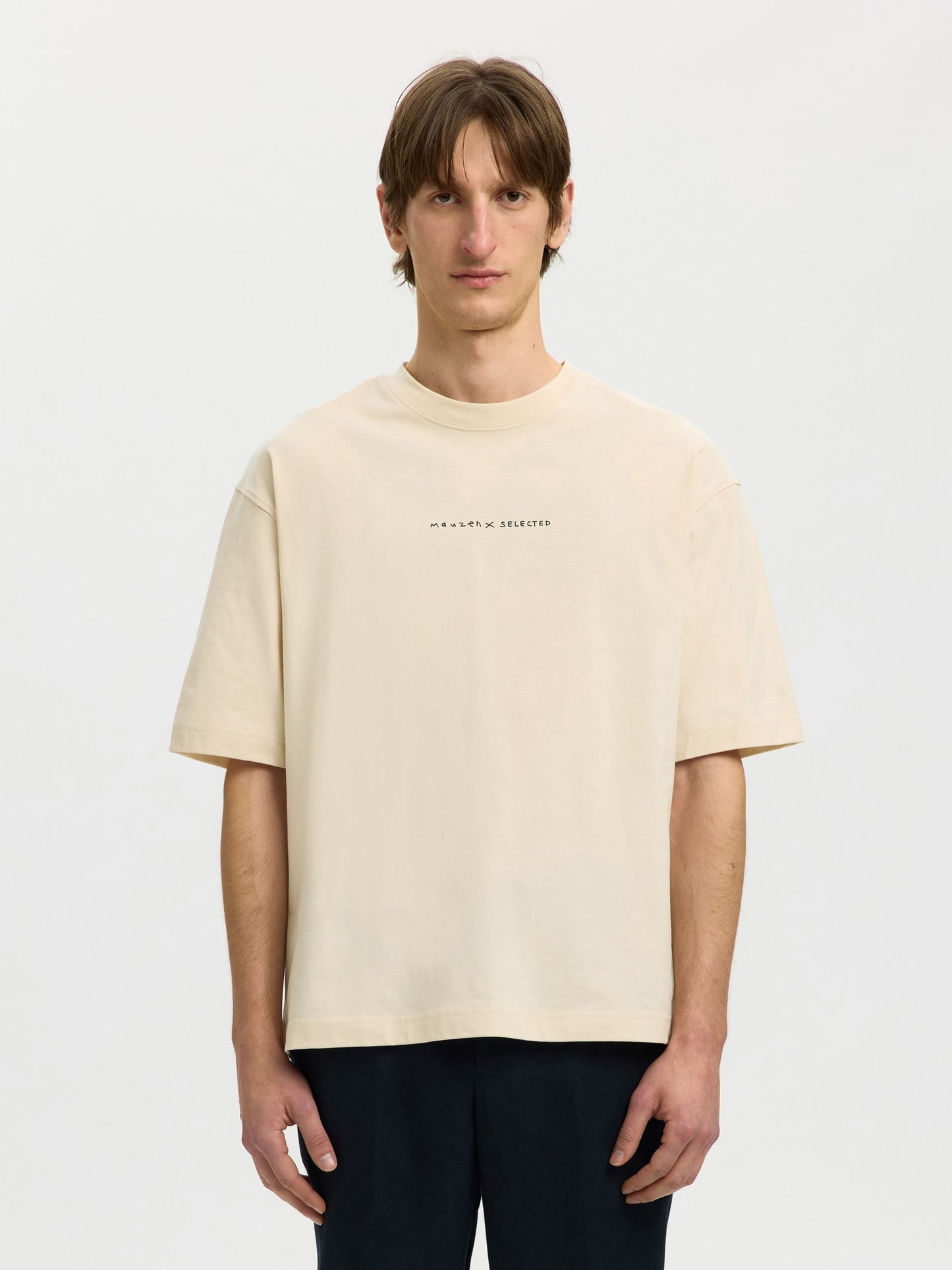 Man wearing a beige t-shirt with text on a white background