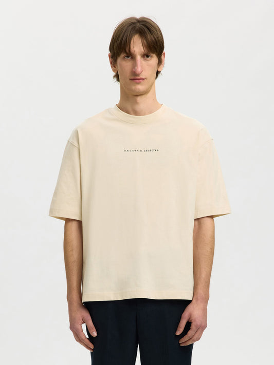 Man wearing a beige t-shirt with text on a white background