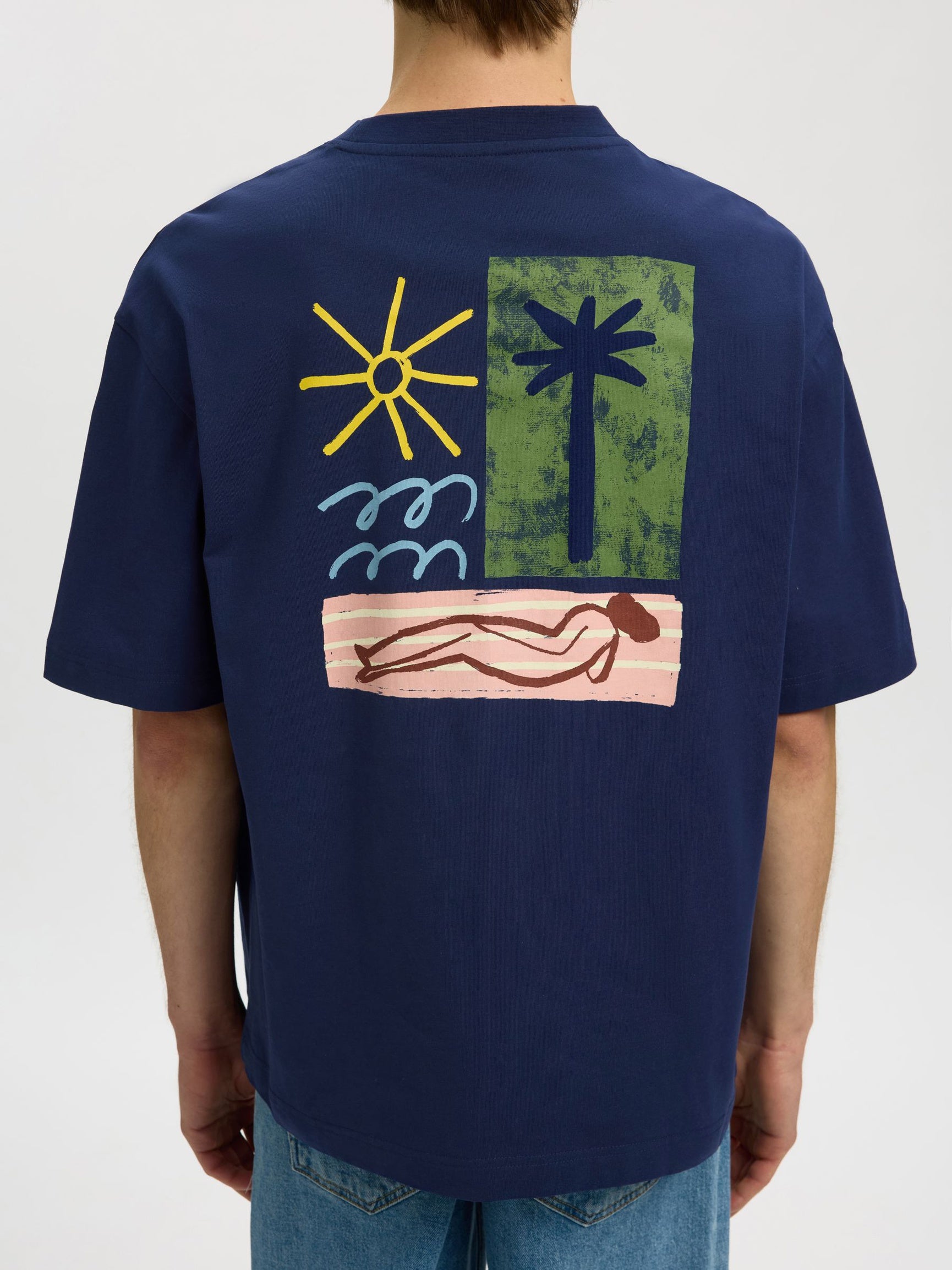 Navy blue t-shirt with a colorful graphic on the back, featuring a sun, palm tree, and person lying down.