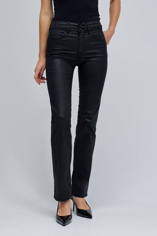 Person wearing black straight-leg jeans on a gray background