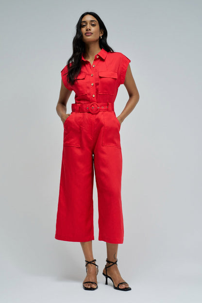 Woman wearing a red jumpsuit on a gray background