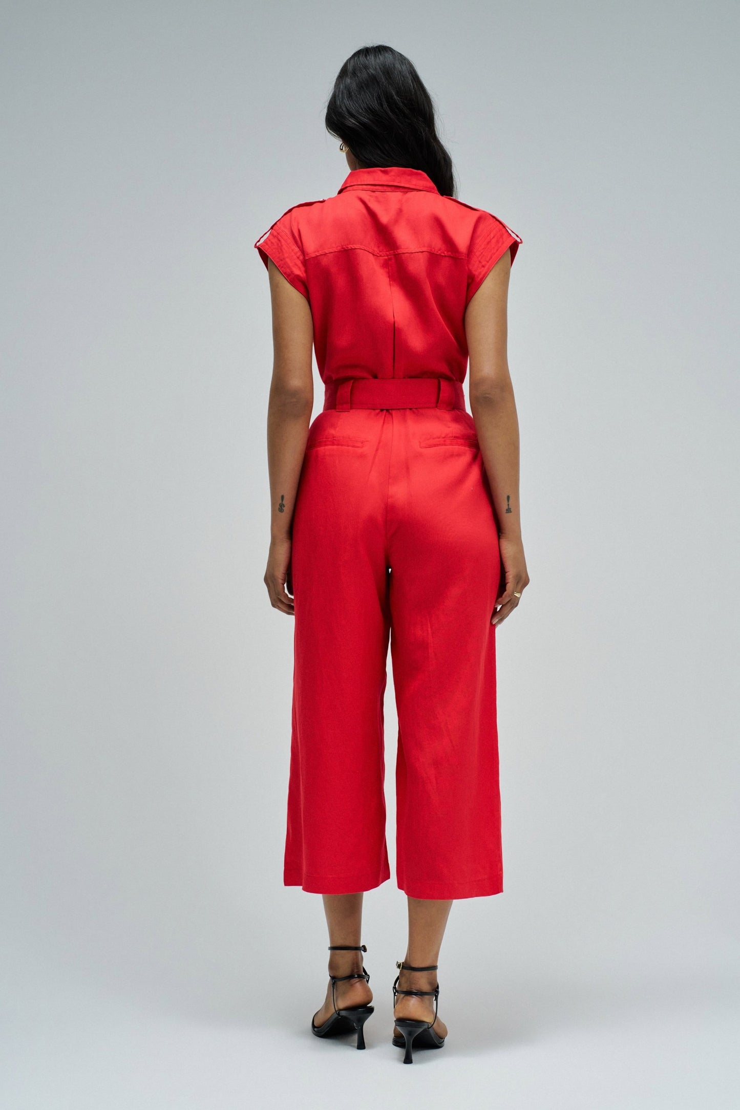 Person wearing a red jumpsuit on a white background