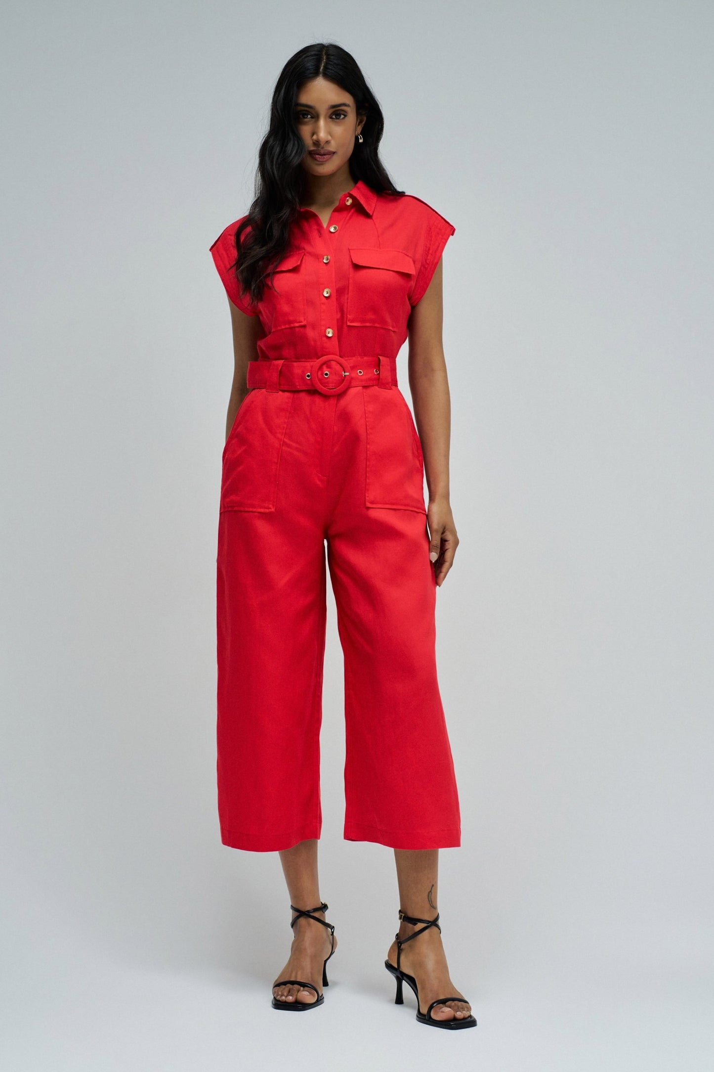 Woman wearing a red jumpsuit on a gray background