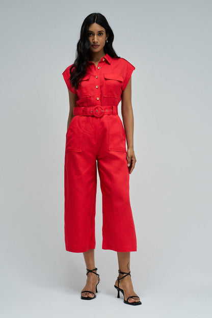 Woman wearing a red jumpsuit on a gray background