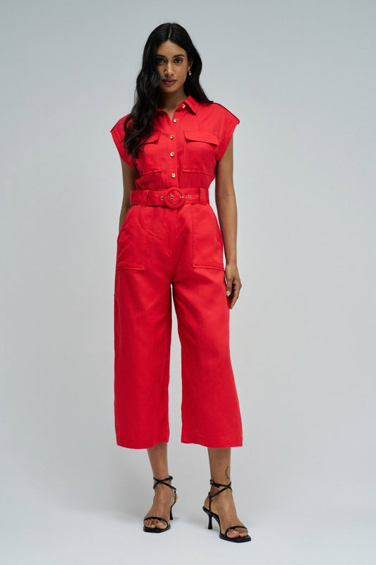 Woman wearing a red jumpsuit on a gray background