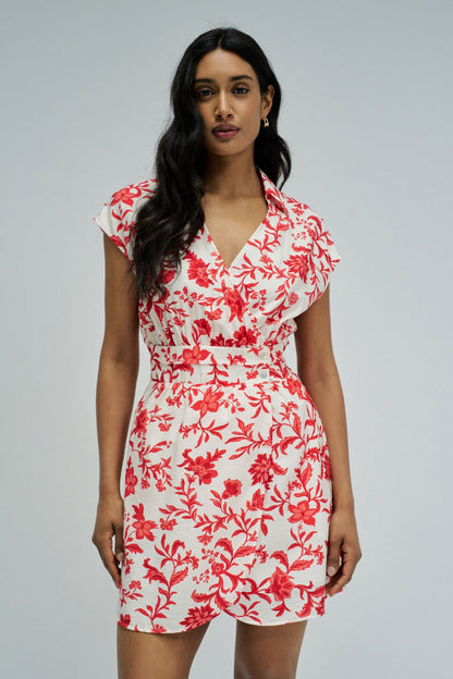 Woman wearing a red floral dress on a gray background