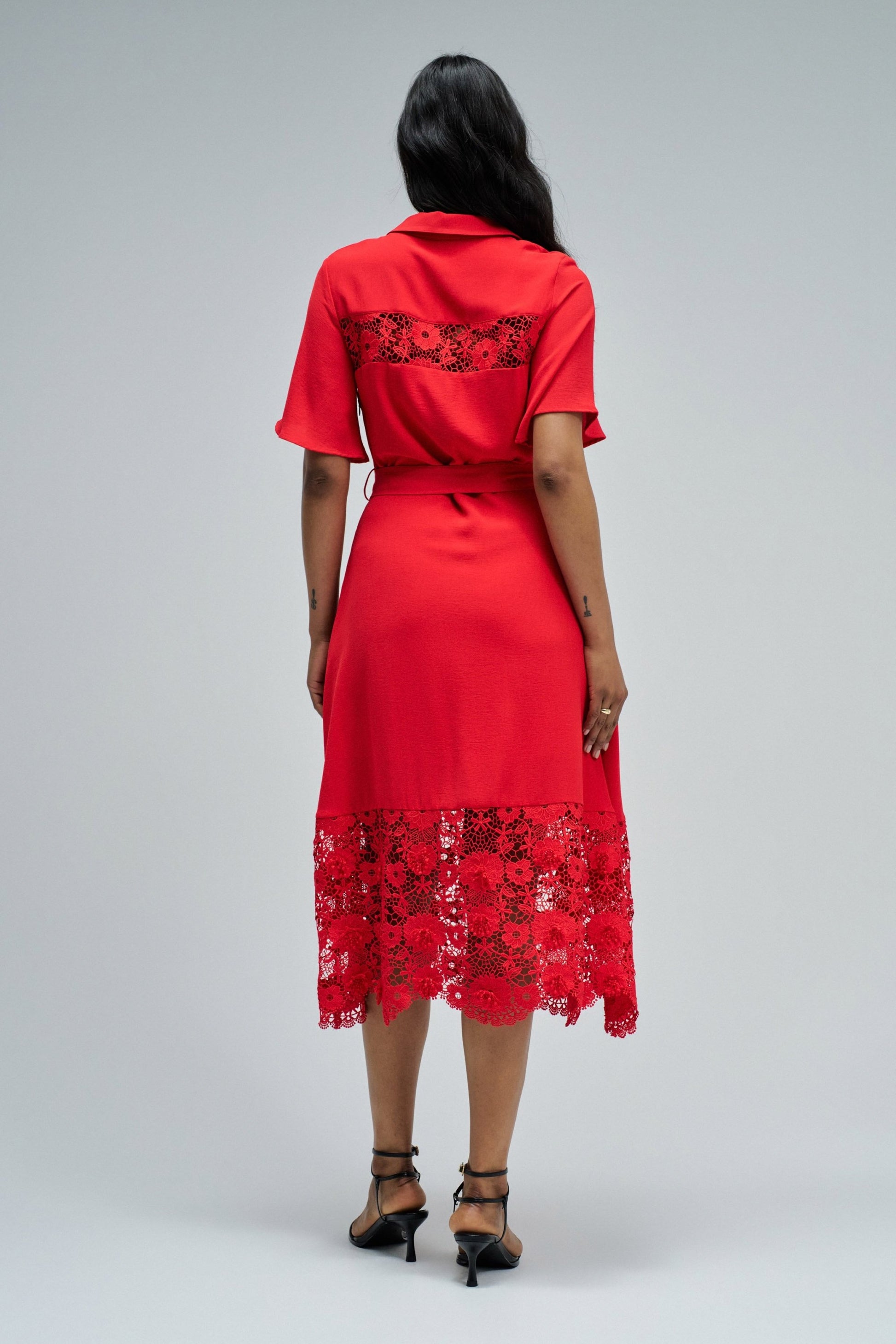 Red dress with lace details on a gray background