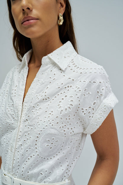 White eyelet dress worn by a model on a plain background