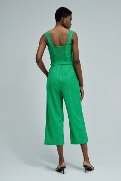 Woman wearing a green jumpsuit on a light gray background