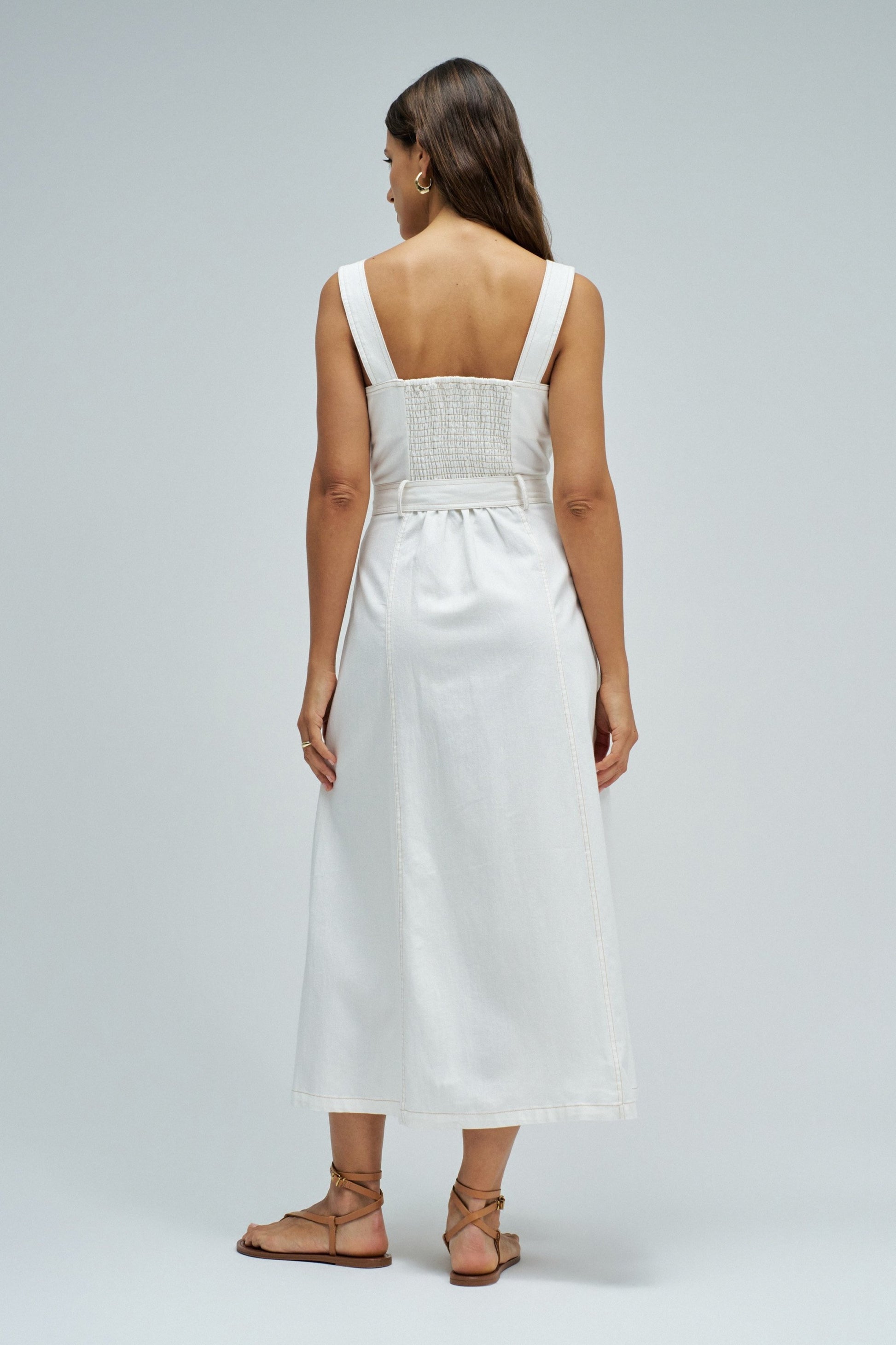 Woman wearing a white dress with a plain background
