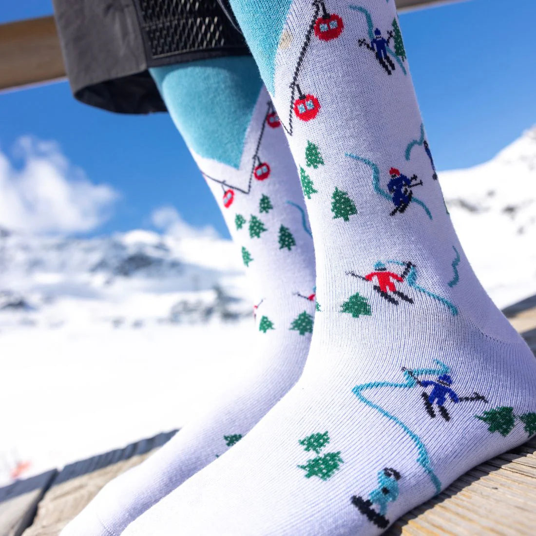 Socks with skiing design worn by a person in a snowy landscape