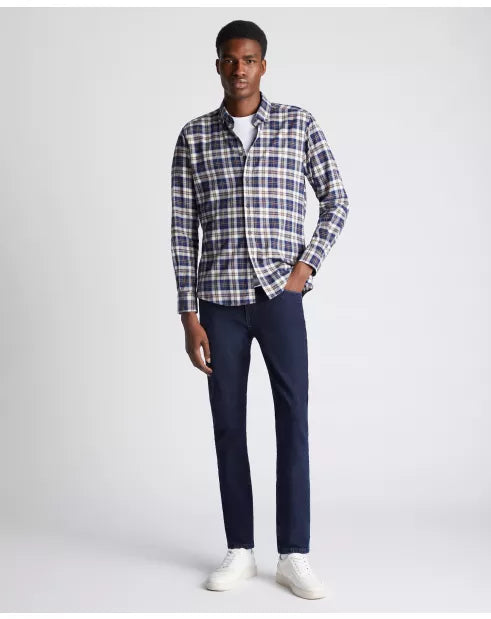 Man wearing a plaid shirt and dark pants on a white background