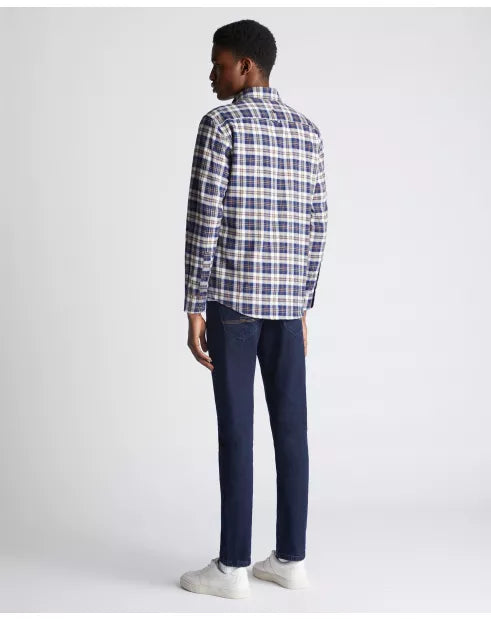 Person wearing a plaid shirt and dark pants on a white background