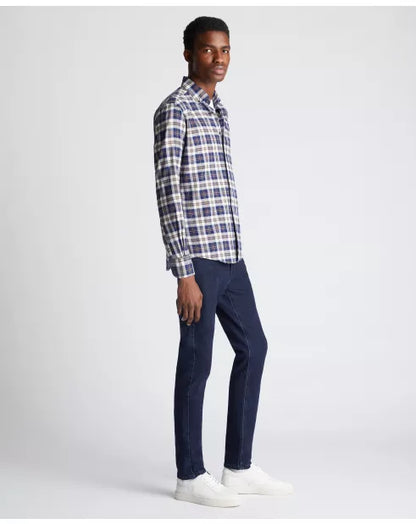 Man wearing a plaid shirt and navy pants on a white background