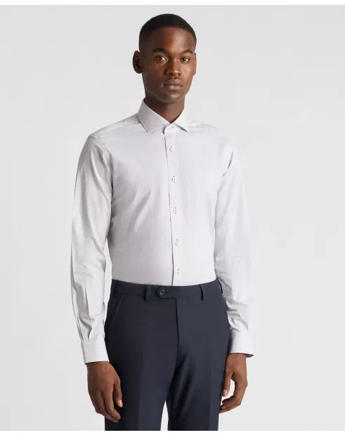 Man wearing a white dress shirt and dark pants on a light gray background