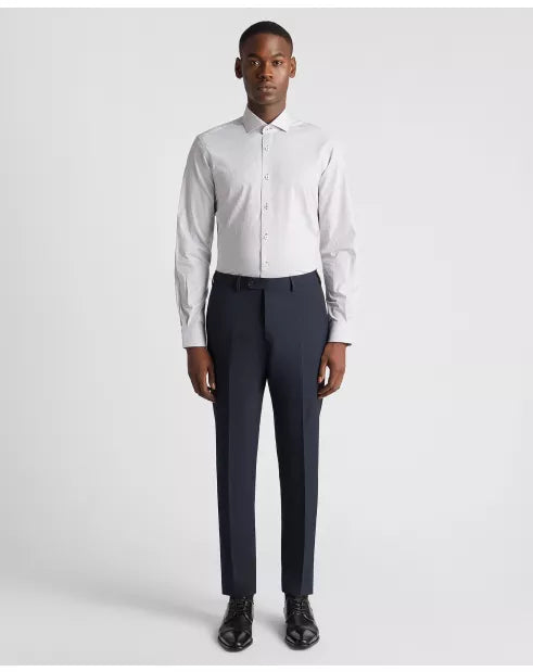 Man wearing a white dress shirt and navy pants on a light gray background