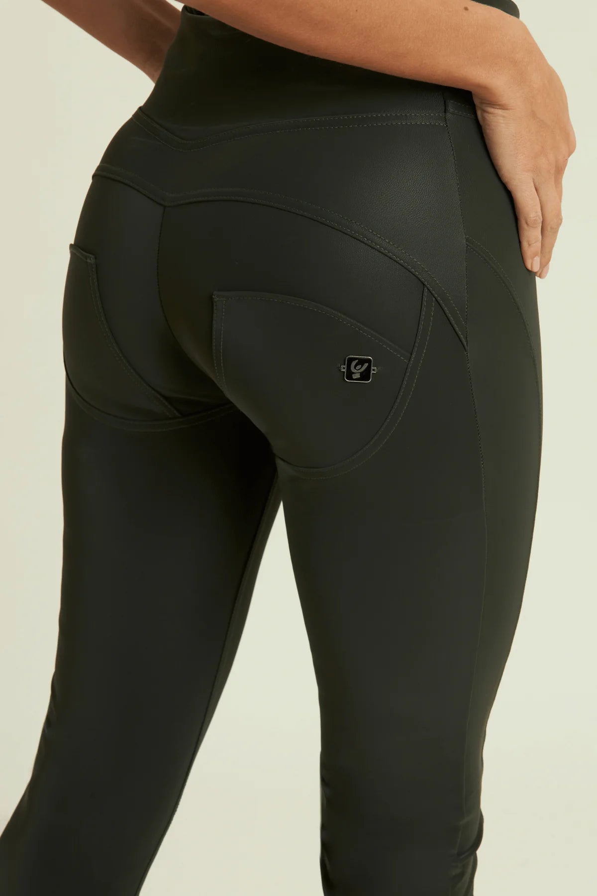 Black leggings with a brand logo on a beige background