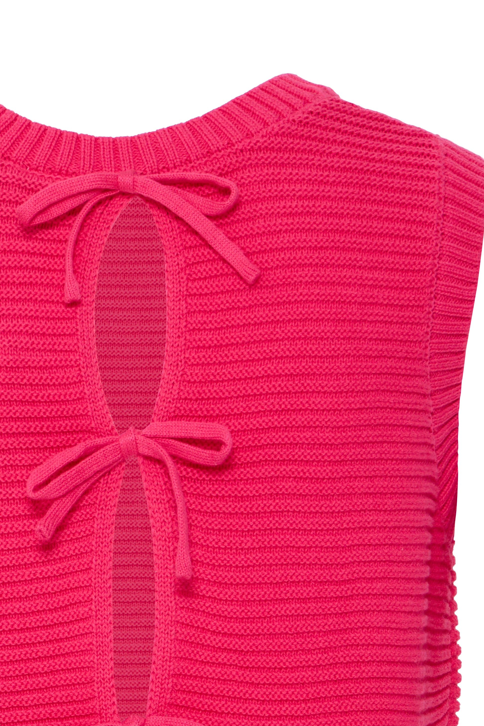 Close-up of a pink knitted vest with bow details on a white background